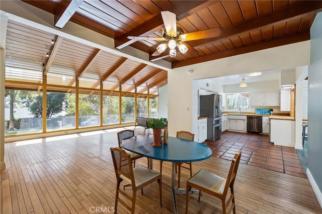 sunroom with a healthy amount of sunlight, vaulted ceiling with beams, and wooden ceiling