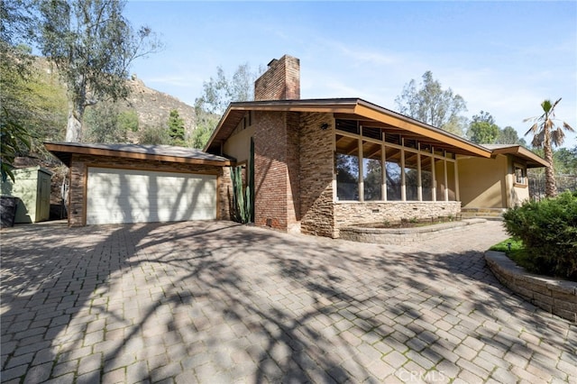 view of side of home with a garage and a mountain view