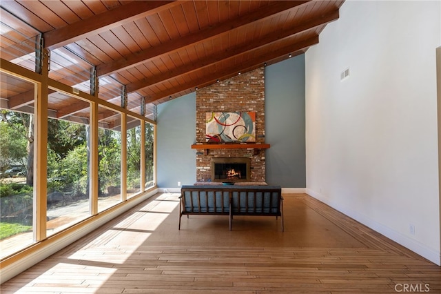 unfurnished sunroom with a brick fireplace, wooden ceiling, and lofted ceiling with beams