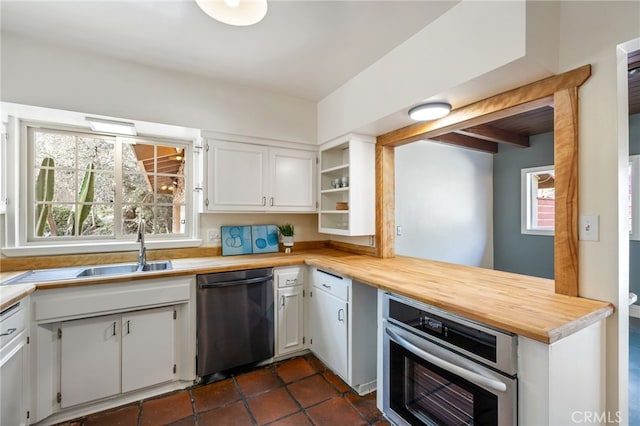 kitchen with dishwashing machine, oven, white cabinetry, and sink