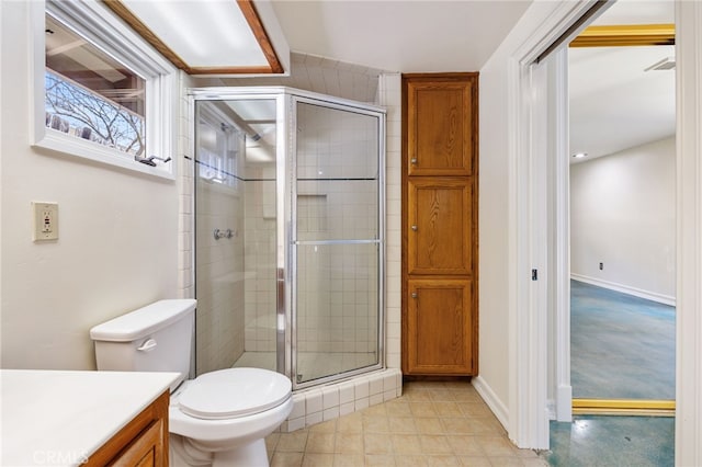 bathroom featuring toilet, vanity, and a shower with door