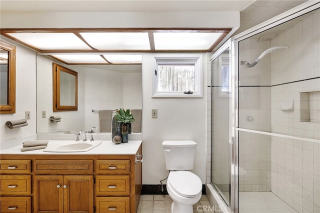 bathroom with vanity, toilet, tile patterned floors, and walk in shower