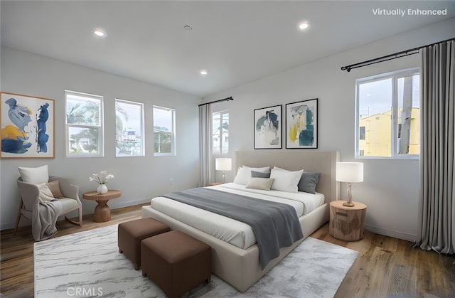 bedroom featuring multiple windows and hardwood / wood-style flooring