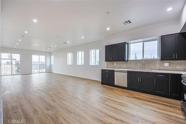 kitchen featuring stainless steel appliances, sink, light hardwood / wood-style flooring, and backsplash