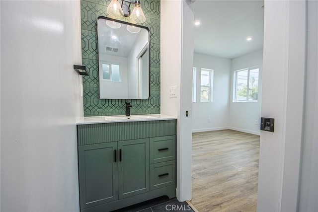 bathroom with tasteful backsplash, vanity, and wood-type flooring