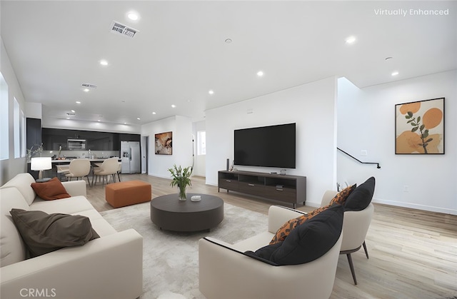 living room featuring sink and light hardwood / wood-style floors