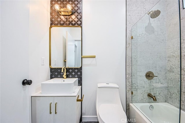 full bathroom featuring tiled shower / bath, vanity, and toilet