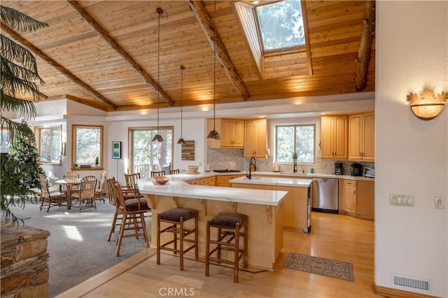 42848 Eagle Flight Pl, Big Bear Lake, CA 92315 - kitchen featuring a breakfast bar area, hanging light fixtures, light brown cabinets, dishwasher, and kitchen peninsula