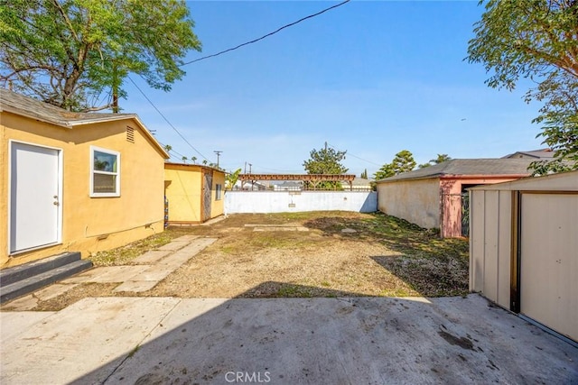 view of yard featuring a storage shed and a patio