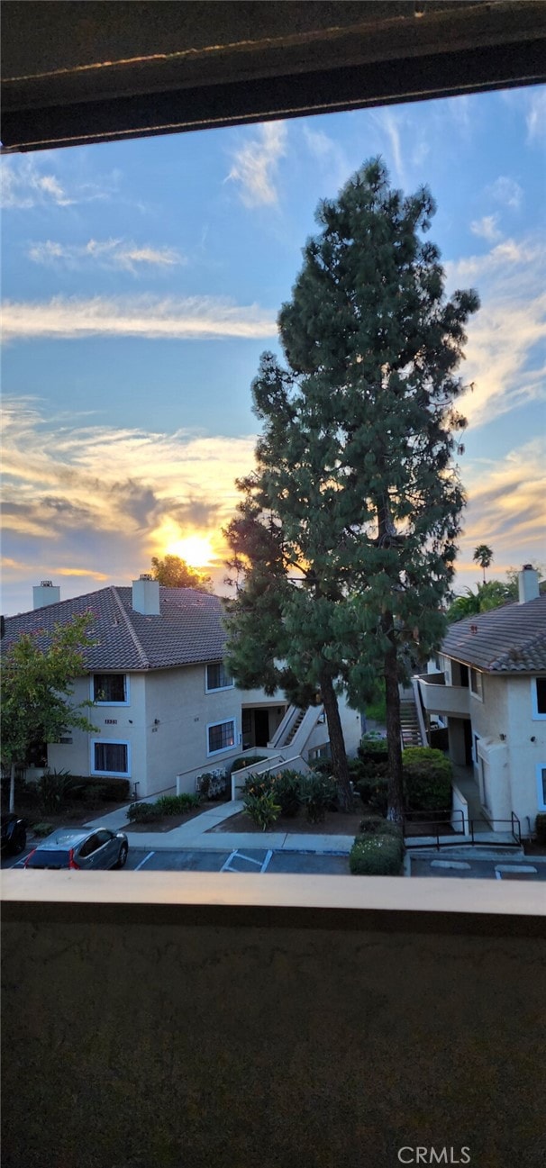 view of front of property featuring a chimney and a balcony