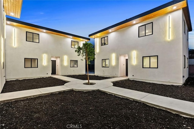 rear view of property featuring a patio area and stucco siding