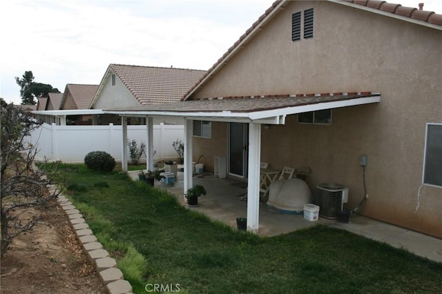 rear view of property with central AC, a lawn, and a patio area