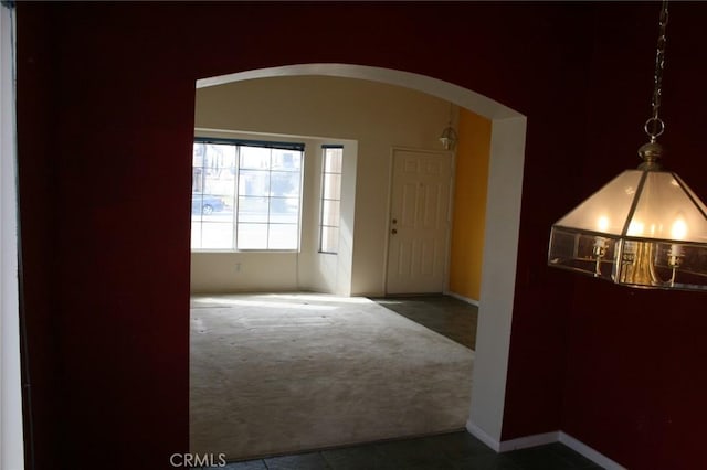 foyer entrance featuring dark colored carpet