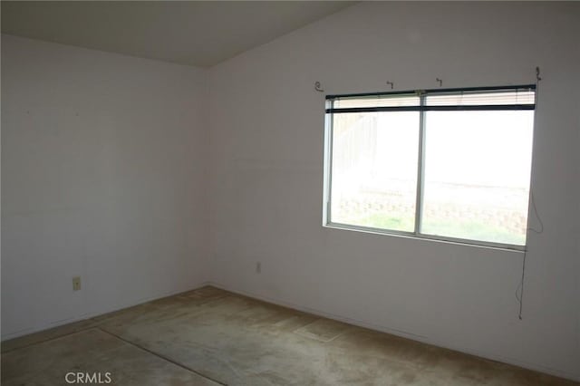 spare room featuring lofted ceiling