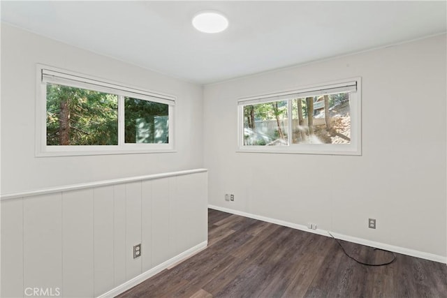 unfurnished room featuring dark wood finished floors and baseboards