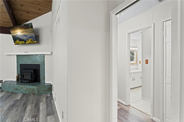 hall with wooden ceiling, beamed ceiling, light wood-style flooring, and baseboards