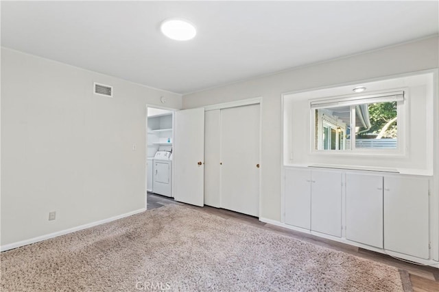 unfurnished bedroom featuring light wood finished floors, a closet, visible vents, washing machine and dryer, and baseboards