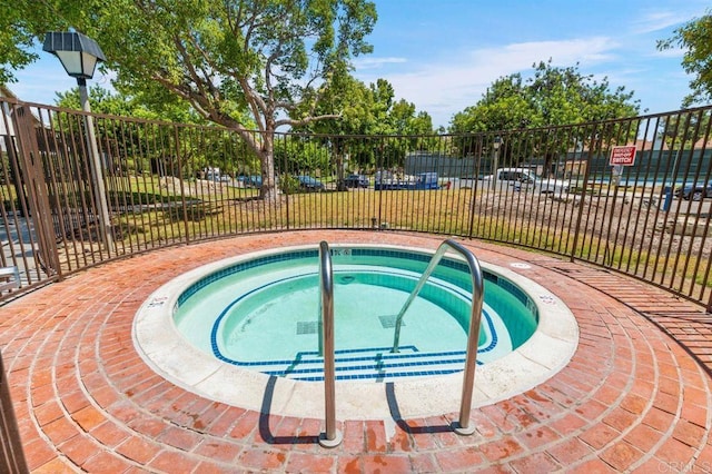 view of swimming pool featuring a hot tub