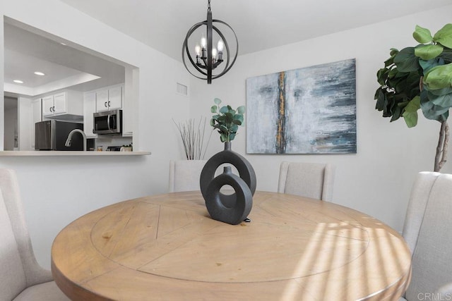 dining space with sink and a notable chandelier