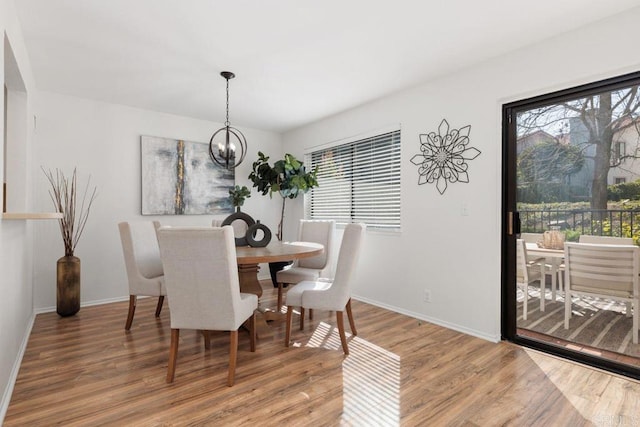 dining area featuring hardwood / wood-style floors and an inviting chandelier