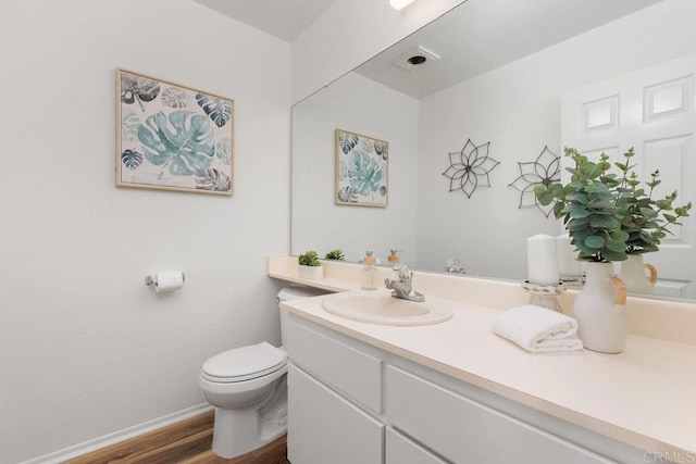 bathroom with hardwood / wood-style floors, vanity, and toilet