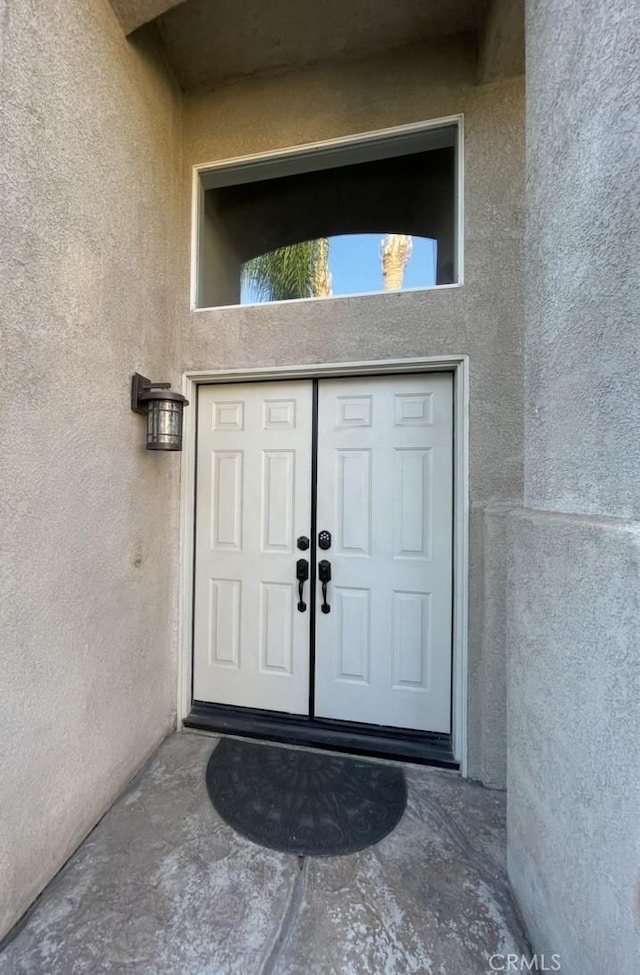 entrance to property featuring stucco siding