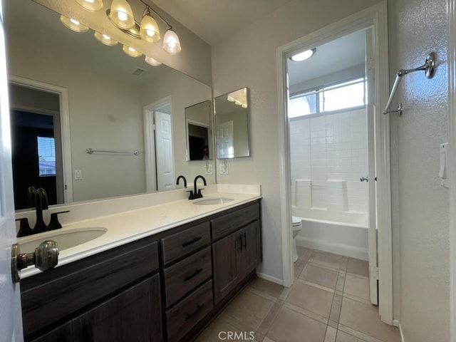 bathroom featuring toilet, tile patterned flooring, double vanity, and a sink