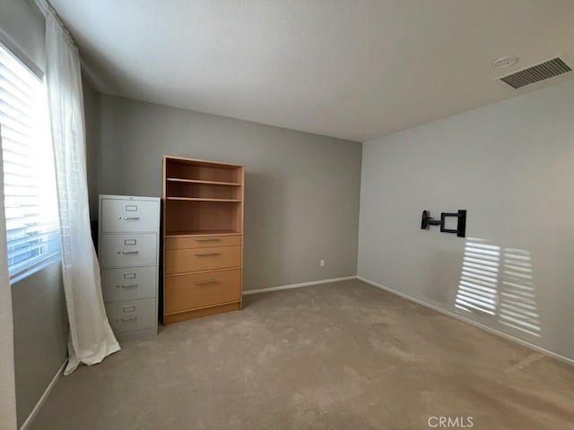 unfurnished bedroom with light carpet, baseboards, and visible vents