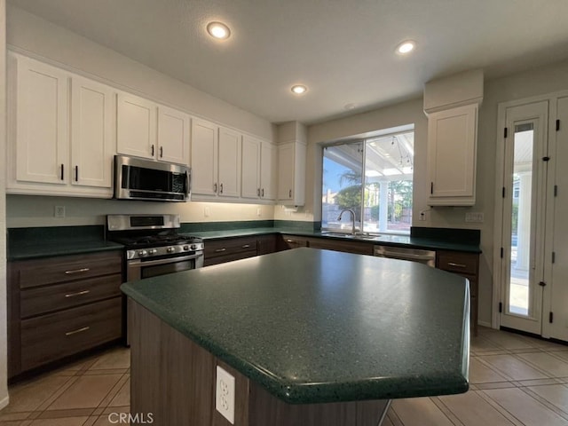 kitchen featuring dark countertops, white cabinetry, and stainless steel appliances