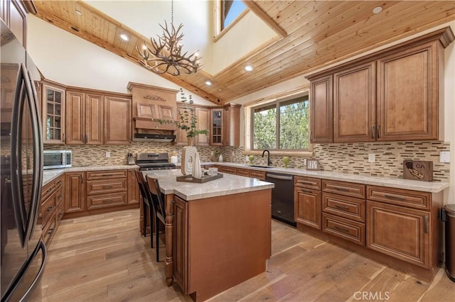 43625 Wolf Rd, Big Bear Lake, CA 92315 - kitchen with a kitchen island, decorative light fixtures, stainless steel dishwasher, black fridge, and light wood-type flooring