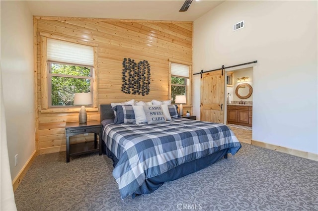 43625 Wolf Rd, Big Bear Lake, CA 92315 - carpeted bedroom featuring multiple windows, a barn door, high vaulted ceiling, and wooden walls