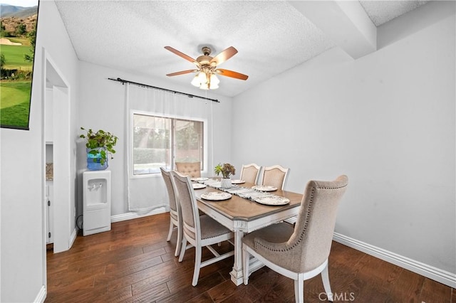 dining room featuring dark hardwood / wood-style flooring, ceiling fan, and a textured ceiling