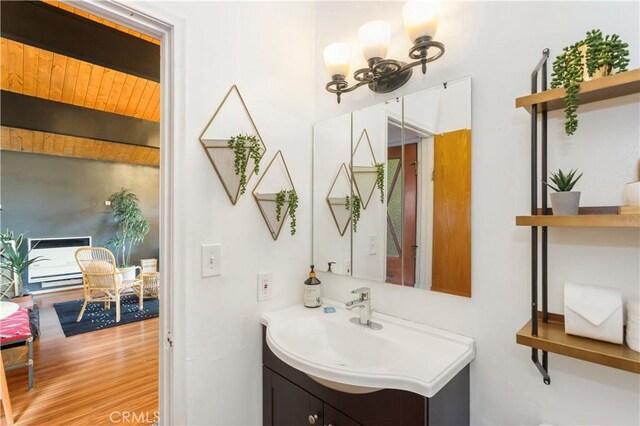 579 E Victoria Ct, Lake Arrowhead, CA 92352 - bathroom with an inviting chandelier, beam ceiling, vanity, and wood finished floors