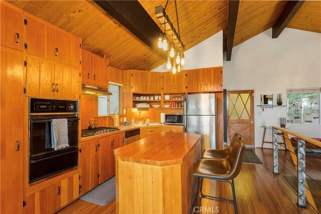 579 E Victoria Ct, Lake Arrowhead, CA 92352 - kitchen featuring a warming drawer, appliances with stainless steel finishes, beamed ceiling, dark wood finished floors, and under cabinet range hood