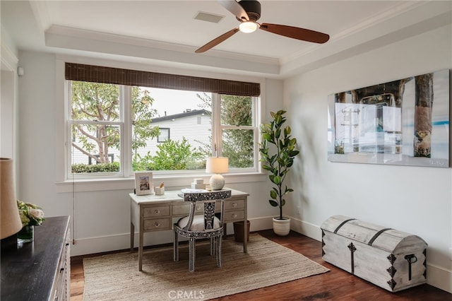 home office featuring ornamental molding, dark wood-type flooring, ceiling fan, and a tray ceiling