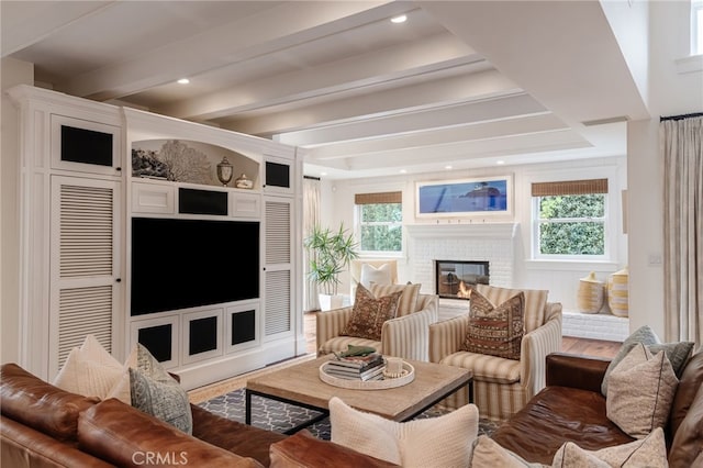 living room featuring beam ceiling and a fireplace