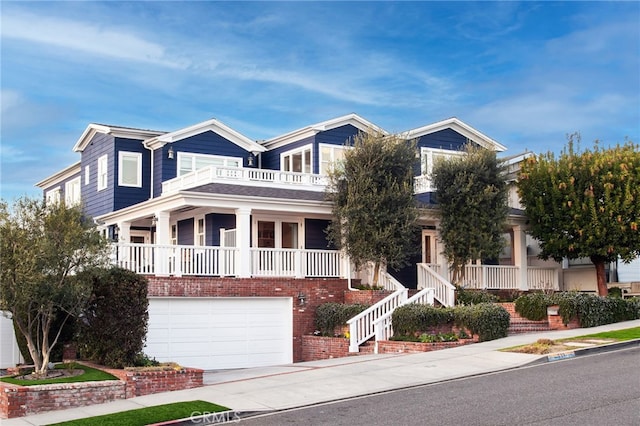 view of front of house with a balcony, stairway, an attached garage, covered porch, and concrete driveway