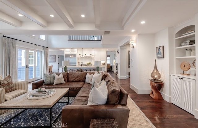 living room with built in features, dark hardwood / wood-style flooring, and beam ceiling