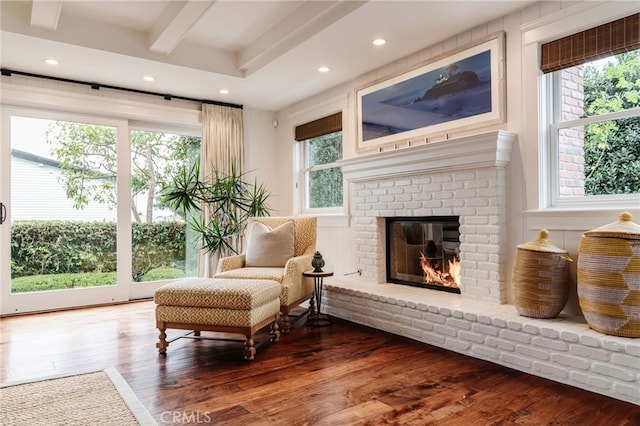 sitting room featuring hardwood / wood-style flooring, a fireplace, and beam ceiling