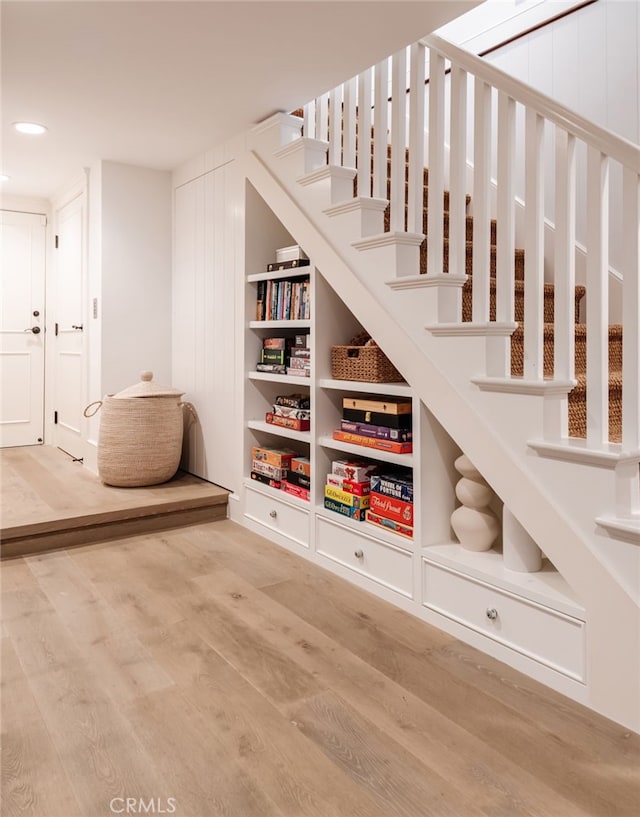 stairway featuring hardwood / wood-style floors and built in shelves