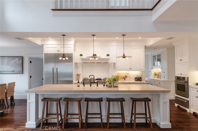 kitchen featuring hanging light fixtures, a breakfast bar area, stainless steel oven, and a spacious island