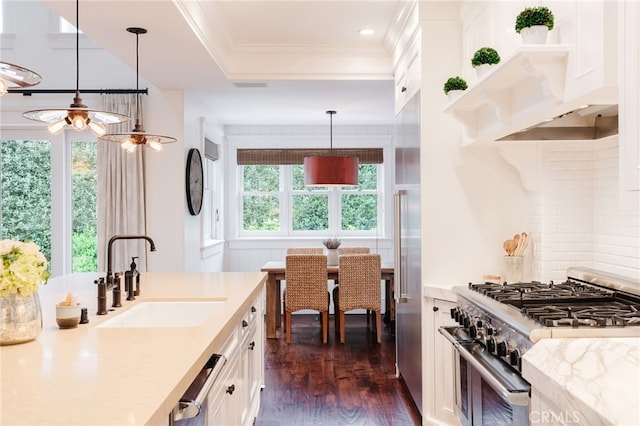 kitchen with decorative light fixtures, sink, white cabinets, stainless steel range, and dark wood-type flooring