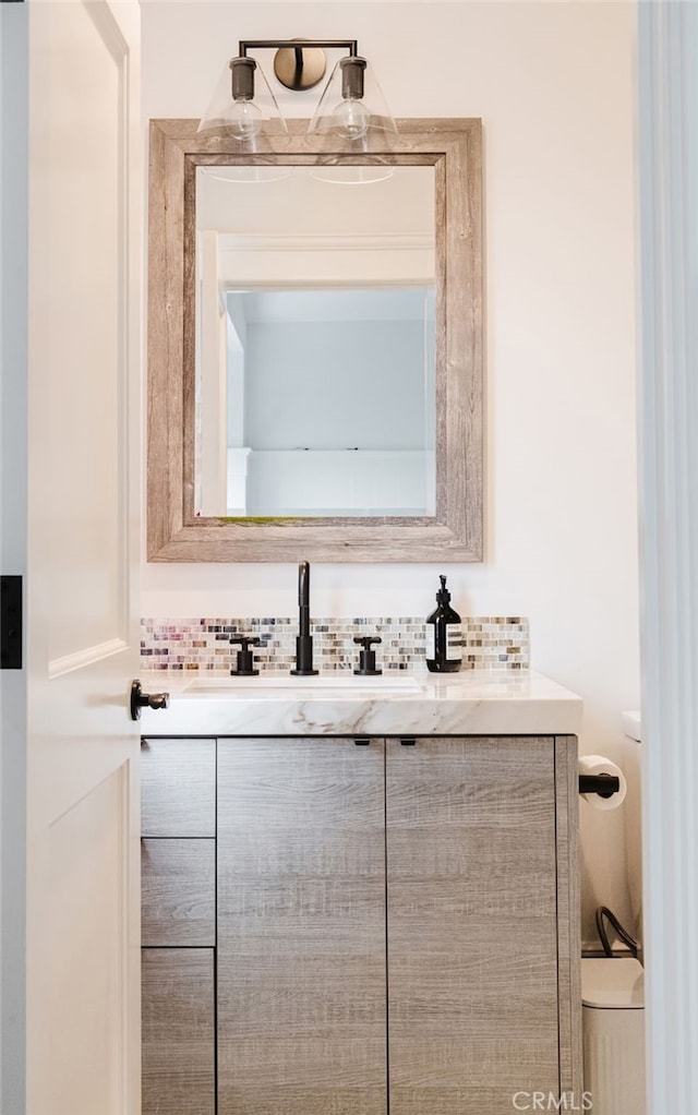 bathroom featuring tasteful backsplash and vanity