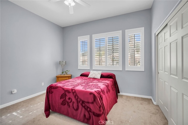 carpeted bedroom featuring ceiling fan and a closet