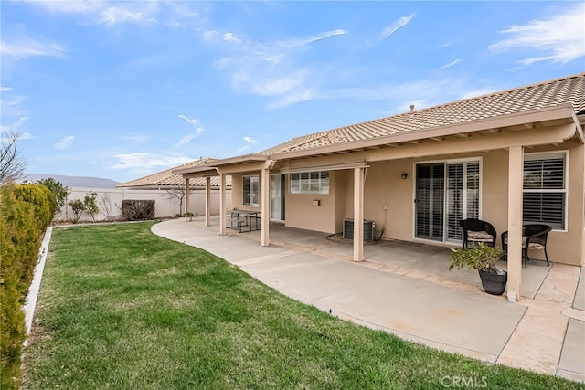 rear view of property with a patio, central air condition unit, and a lawn