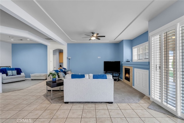carpeted living room with ceiling fan