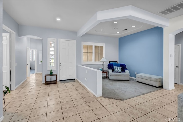 tiled entrance foyer featuring beamed ceiling