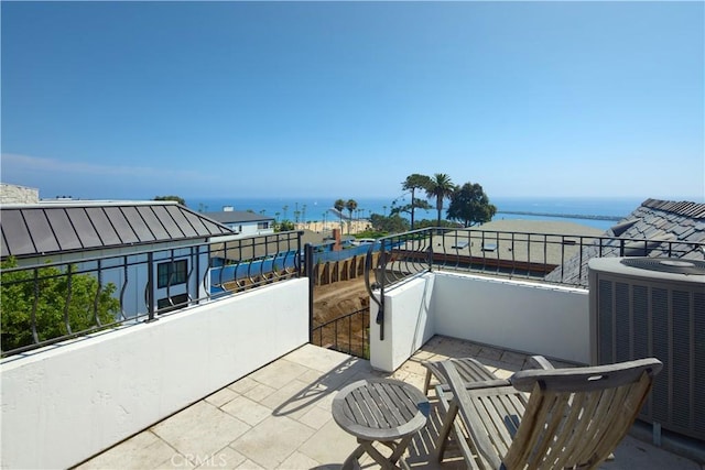 view of patio / terrace featuring cooling unit, a balcony, and a water view