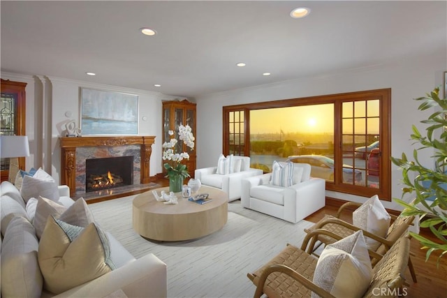 living room with ornamental molding, a premium fireplace, and light hardwood / wood-style flooring