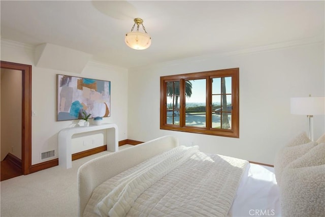 bedroom with ornamental molding and carpet floors